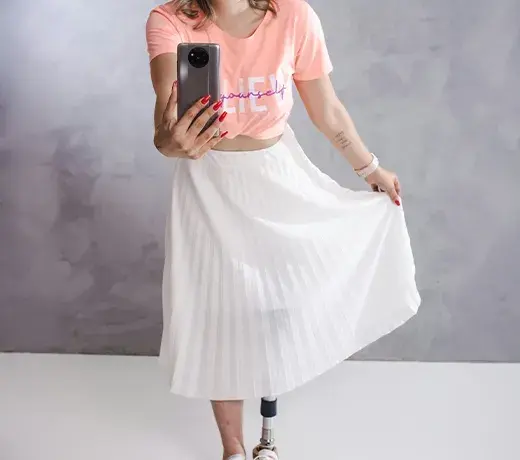 look femme avec un t-shirt noué et une jupe plissée