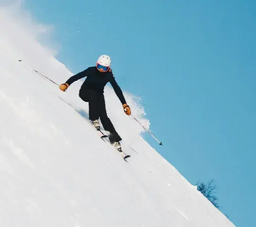 femme skiant sur la piste enneigée avec des vêtements de ski noirs